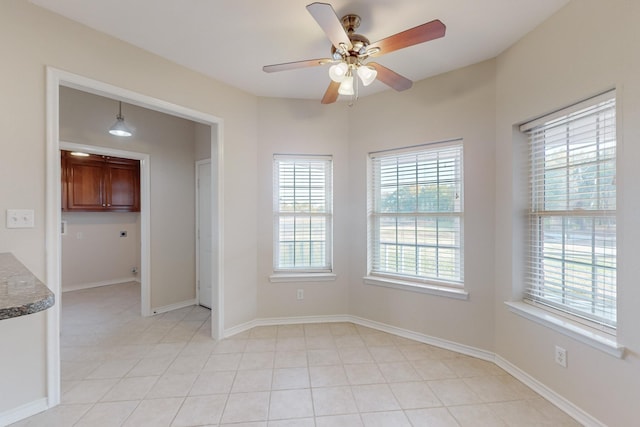 unfurnished room with light tile patterned floors and ceiling fan