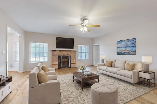 living room featuring ceiling fan, light hardwood / wood-style floors, and a healthy amount of sunlight