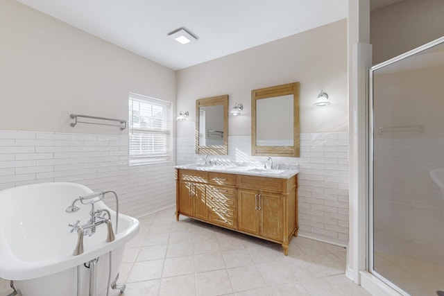 bathroom featuring independent shower and bath, vanity, tile patterned flooring, and tile walls