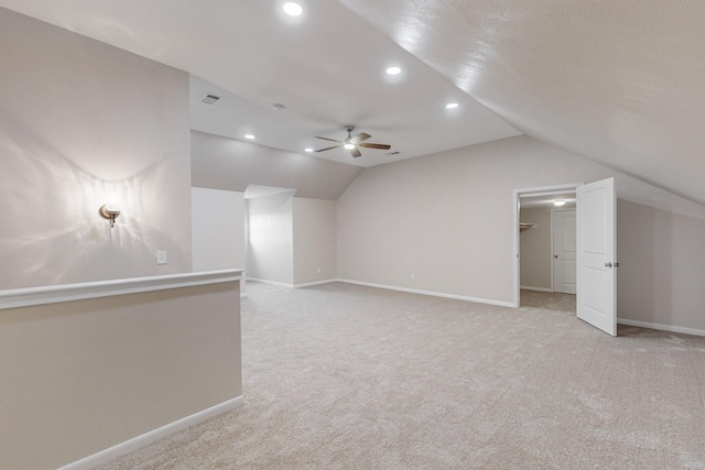 bonus room with vaulted ceiling, light carpet, and ceiling fan