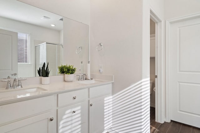 bathroom with vanity, an enclosed shower, and hardwood / wood-style flooring