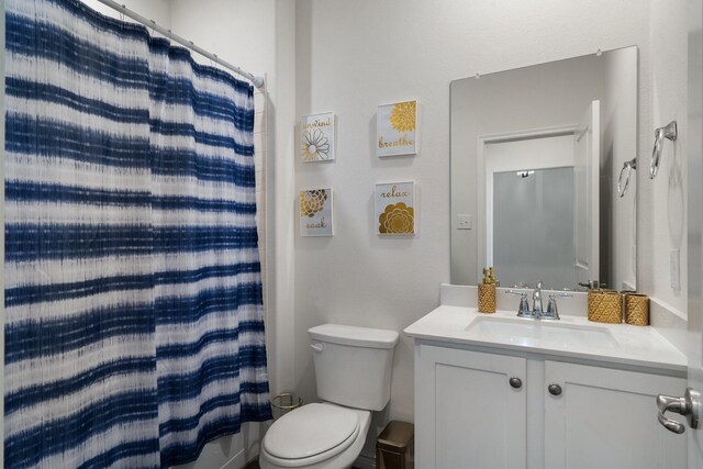 bathroom with vanity, toilet, and curtained shower