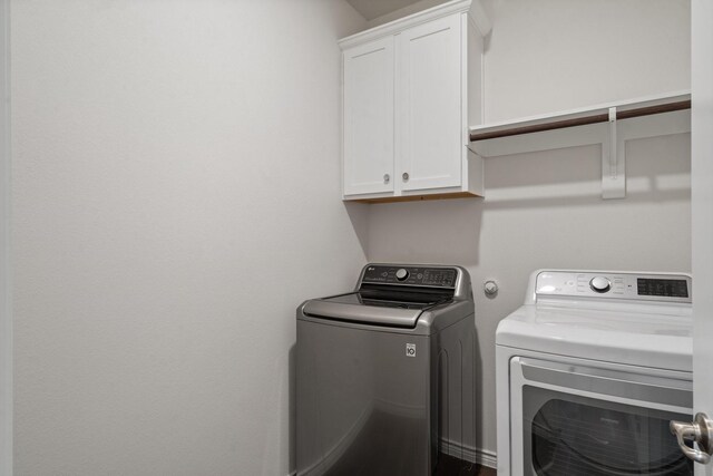 washroom featuring cabinets and independent washer and dryer