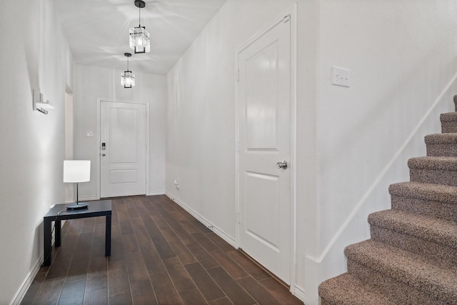 entrance foyer featuring dark wood-type flooring and an inviting chandelier