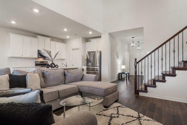 living room with sink and dark wood-type flooring