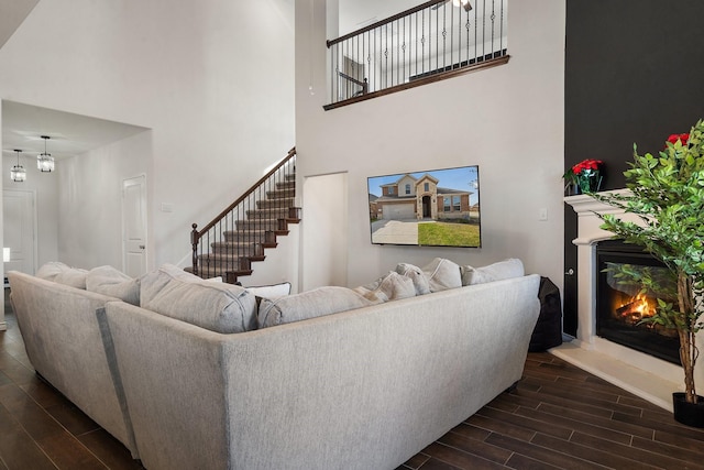 living room with dark hardwood / wood-style flooring, a chandelier, and a high ceiling