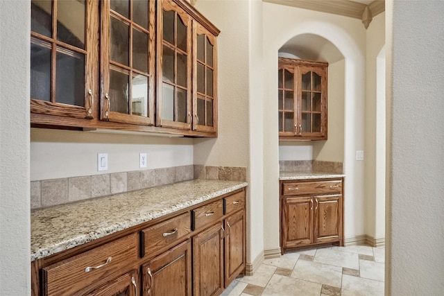 kitchen featuring light stone countertops and ornamental molding