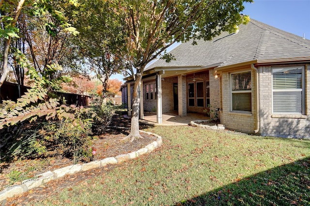 rear view of property with a lawn and a patio