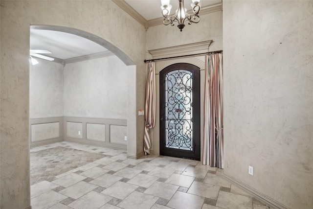 entryway with ceiling fan with notable chandelier and ornamental molding