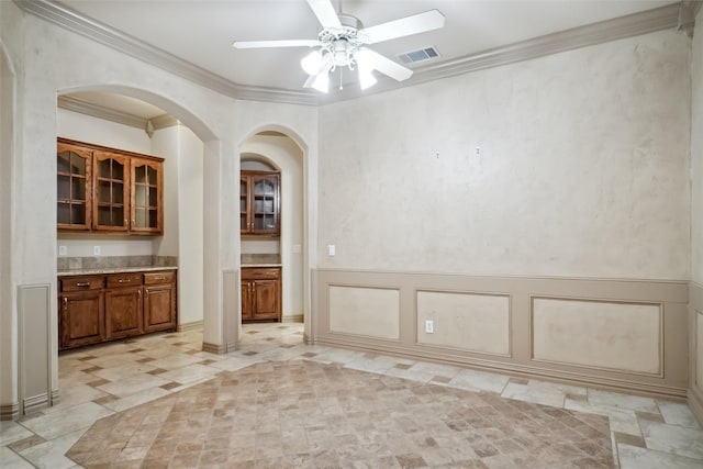 unfurnished dining area featuring ceiling fan and crown molding