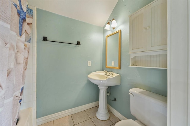 bathroom with tile patterned floors, shower / bath combo with shower curtain, and toilet