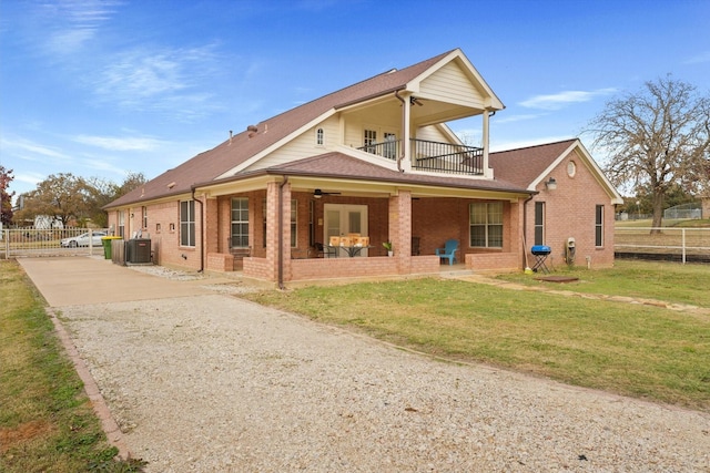 rear view of property with a balcony, central AC, ceiling fan, and a lawn