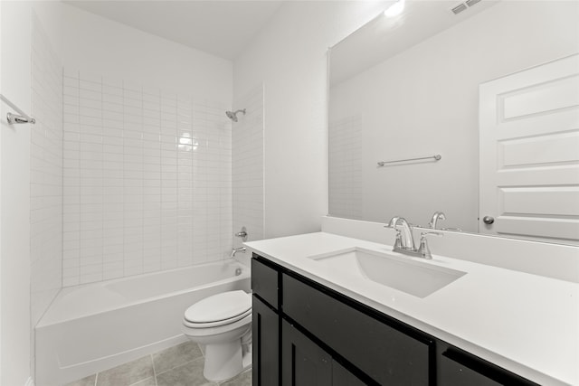 full bathroom featuring toilet, tiled shower / bath, tile patterned floors, and vanity