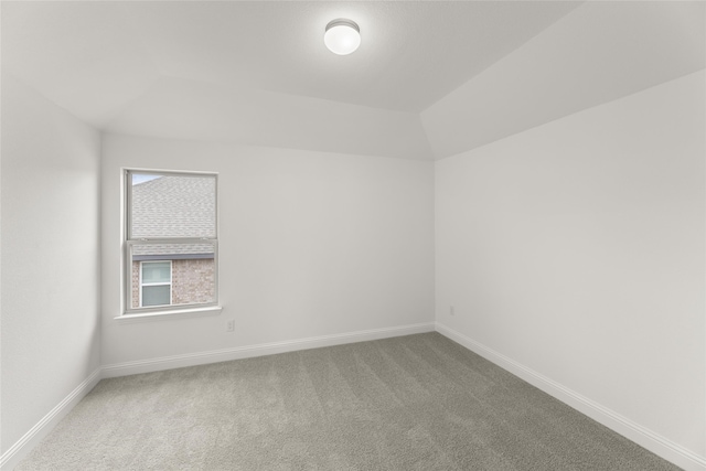 spare room with carpet floors and lofted ceiling