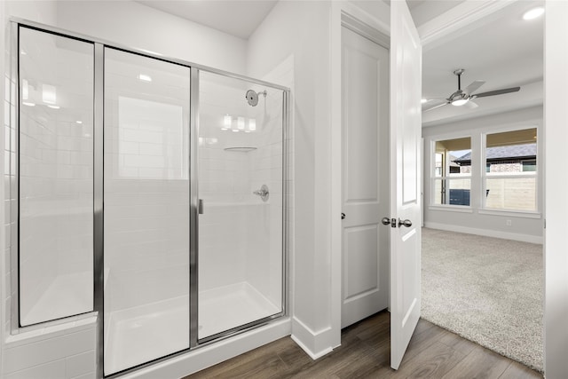 bathroom featuring ceiling fan, a shower with door, and wood-type flooring