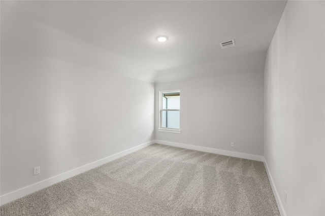 empty room with carpet floors and lofted ceiling