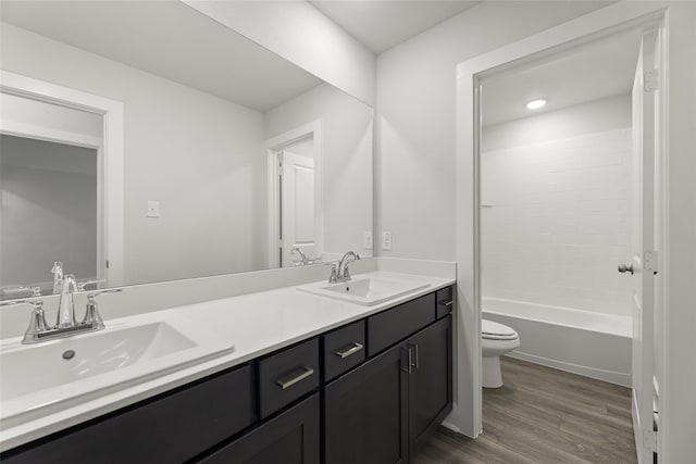 full bathroom featuring hardwood / wood-style flooring, vanity, toilet, and bathtub / shower combination