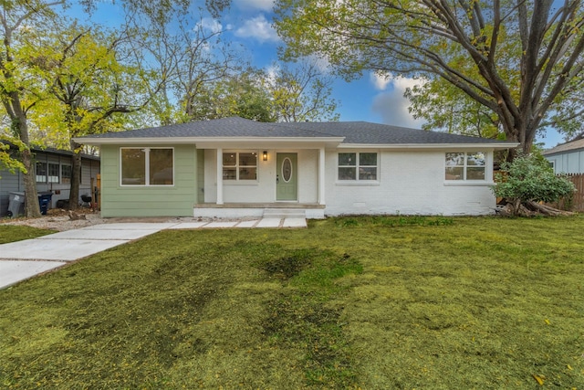 single story home featuring covered porch and a front lawn