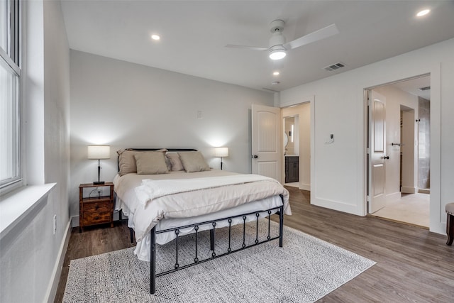 bedroom with hardwood / wood-style flooring, ceiling fan, and ensuite bath