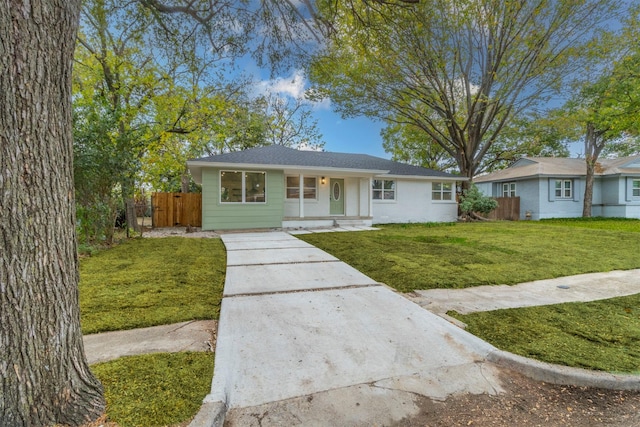 ranch-style home featuring covered porch and a front lawn