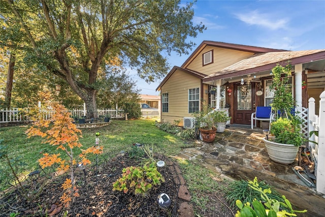 rear view of property with fence and a lawn