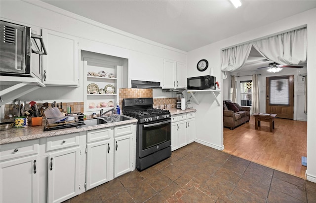 kitchen featuring under cabinet range hood, open shelves, white cabinetry, light countertops, and black appliances