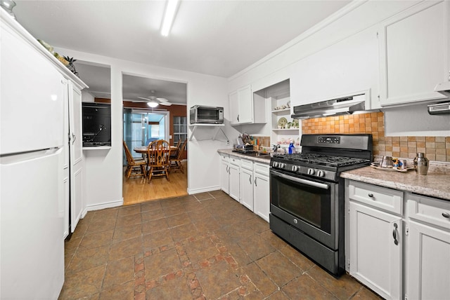 kitchen with stainless steel gas range, tasteful backsplash, white refrigerator, ceiling fan, and white cabinets