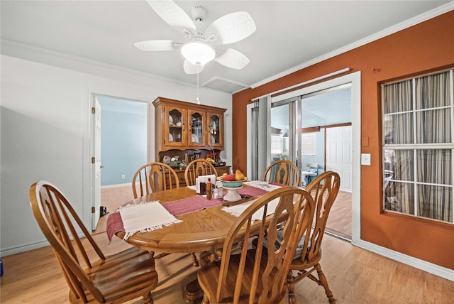 dining area featuring ceiling fan, ornamental molding, and light wood-type flooring