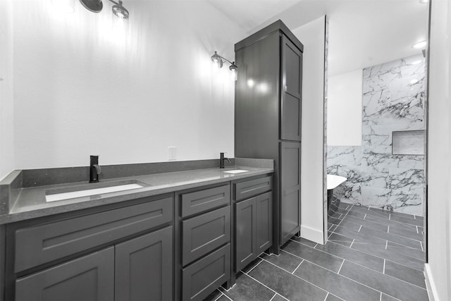 bathroom featuring tile patterned floors, a bathing tub, vanity, and tile walls