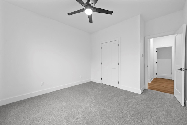 unfurnished bedroom with carpet flooring, ceiling fan, and a closet