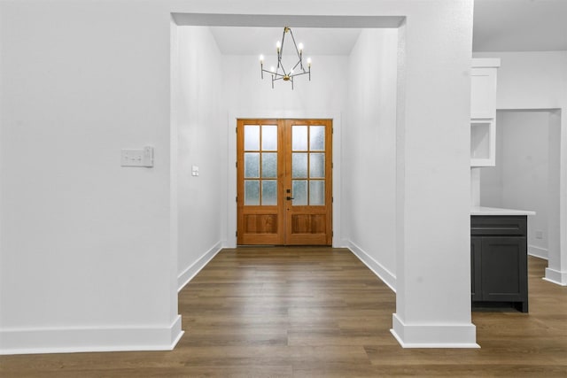 foyer entrance featuring dark hardwood / wood-style flooring, french doors, and a chandelier