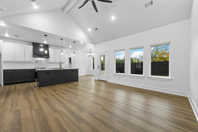 living room featuring hardwood / wood-style floors, high vaulted ceiling, and sink