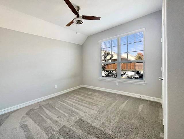 empty room featuring ceiling fan, lofted ceiling, and carpet flooring