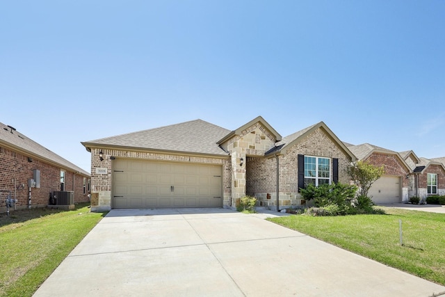 view of front of house with driveway, central air condition unit, stone siding, and an attached garage
