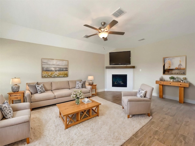 living room featuring hardwood / wood-style flooring, ceiling fan, and lofted ceiling