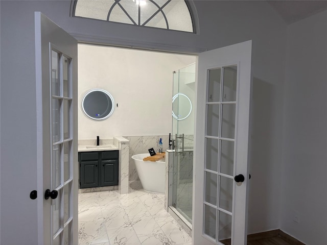 bathroom with separate shower and tub, french doors, and vanity