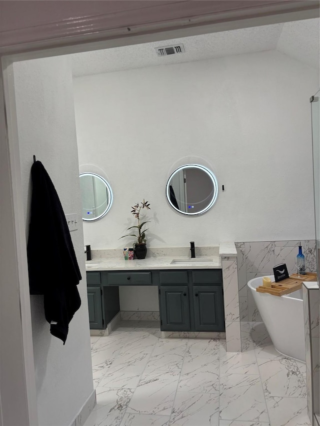 bathroom with tile walls, vanity, a bath, and vaulted ceiling