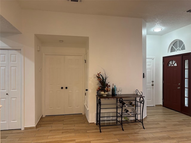 entrance foyer with a textured ceiling and light wood-type flooring