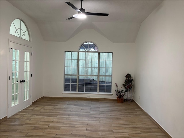 spare room featuring french doors, light hardwood / wood-style flooring, ceiling fan, and lofted ceiling