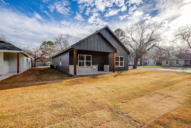 view of front of home with a front lawn and central air condition unit