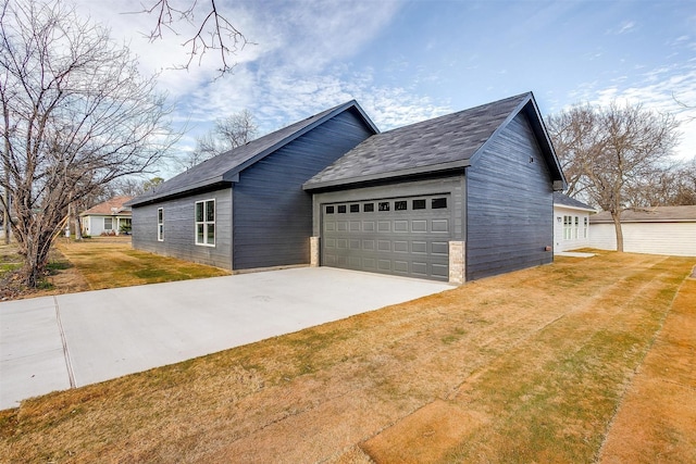 view of side of home featuring a garage and a lawn