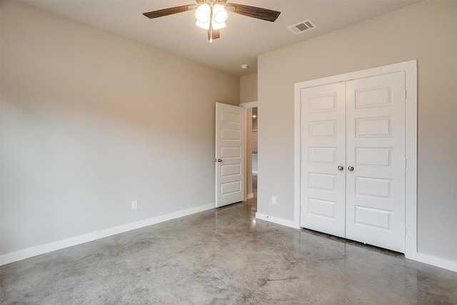 unfurnished bedroom with ceiling fan, concrete flooring, and a closet