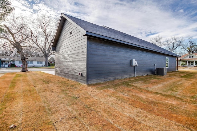 view of home's exterior with cooling unit and a lawn