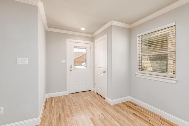 foyer entrance featuring washer / dryer, light wood-type flooring, and crown molding