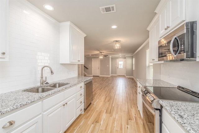 kitchen featuring white cabinetry, ceiling fan, sink, stainless steel appliances, and light wood-type flooring