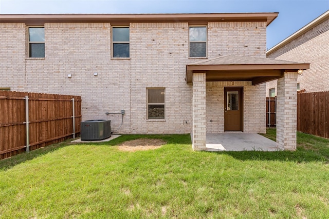 rear view of house with central AC unit, a yard, and a patio