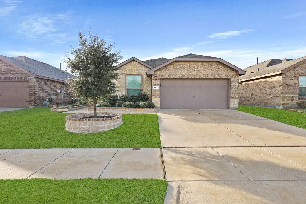 single story home featuring a garage and a front lawn