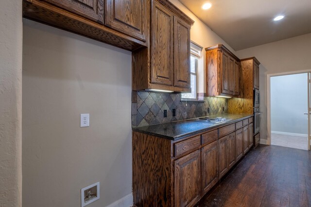 kitchen featuring stainless steel appliances, dark wood-type flooring, and tasteful backsplash