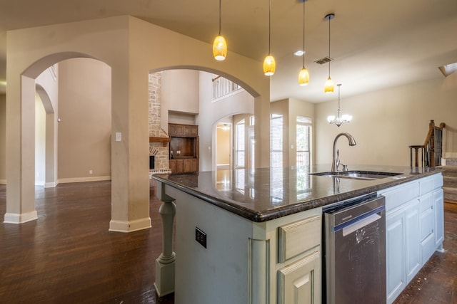 kitchen with dark wood-type flooring, sink, a center island with sink, white cabinetry, and hanging light fixtures