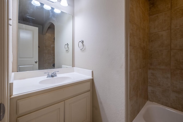 bathroom featuring vanity and tiled shower / bath